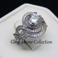 a white gold diamond engagement ring set with an intricate design on the band and center stone