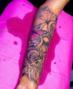 a woman's arm with flowers on it and a butterfly in the middle of her arm