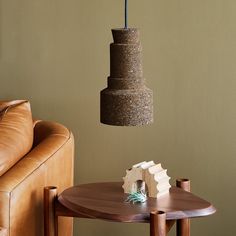 a living room with a couch, table and lamp hanging from it's ceiling