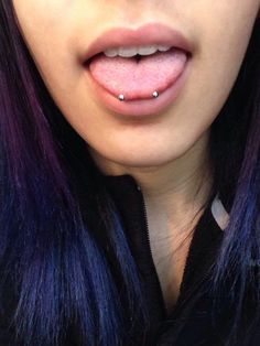 a woman with purple hair and piercings on her lips