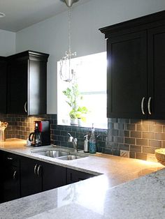 a kitchen with granite counter tops and black cabinets