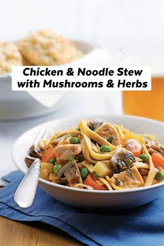 chicken and noodle stew with mushrooms and herbs in a white bowl on a blue napkin