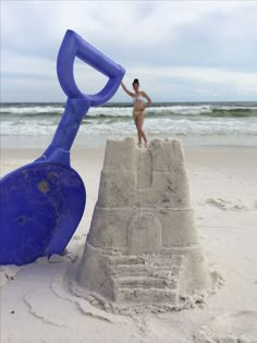 a man standing on top of a blue sand castle