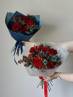 two hands holding bouquets of red roses and succulents