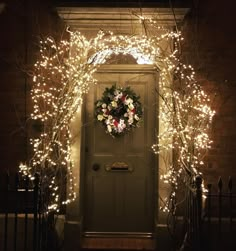 a lighted wreath on the front door of a house