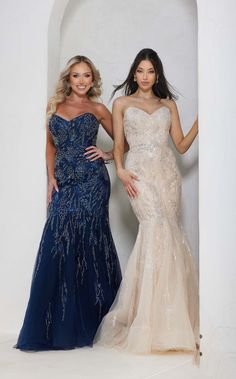 two beautiful women standing next to each other in formal dresses and posing for the camera