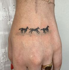 a woman's hand with three horses drawn on the side of her left hand