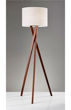 This handsome light with a sleek, light walnut tripod base suits a variety of settings from contemporary, rustic, transitional to loft style.Features: Ten-foot brown fabric-covered cord with three-way rotary switch.Sizing information: 20" x 63". Requires a 150W incandescent or equivalent CFL bulb (not included) Assembly required Wood/fabric Imported Rustic Transitional, Wood Floor Lamp, Cfl Bulbs, Loft Style, Brown Fabric, Goa, Fabric Covered, Tripod, Beams