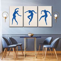 three blue silhouettes are on the wall above a dining room table