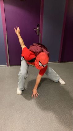 a man in a red shirt is doing a handstand