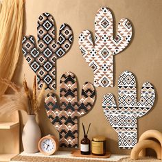 three wooden cactus wall hangings next to a clock and other items on a shelf