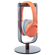 an orange headphone stand with two headsets on it's sides and one in the middle