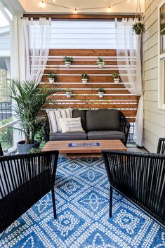 two black chairs sitting on top of a blue and white rug next to a couch