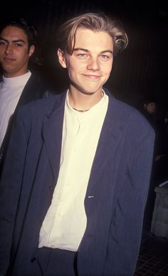 a man in a suit and tie standing next to another man