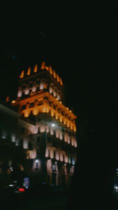 a tall building lit up at night in the dark