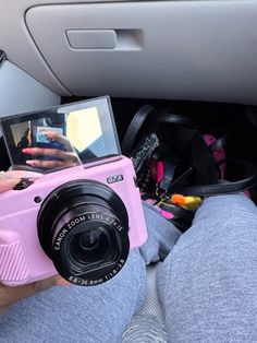 a person holding a pink camera in their lap