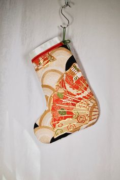 an ornament hanging on a white wall with a red and gold stocking