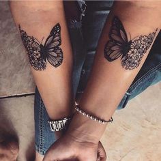 two people holding hands with butterfly tattoos on their arms, both wearing matching bracelets