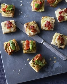 small appetizers are arranged on a tray with a knife