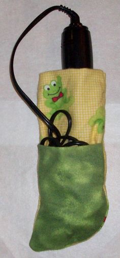 a cell phone holder made out of fabric with a green frog on it's side