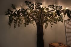 a tree with lights on it in the corner of a room