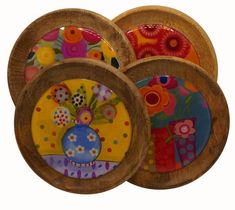 four wooden plates with colorful designs on them are stacked in the same pattern and shape