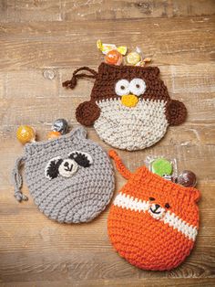 three crocheted coin purses sitting on top of a wooden table