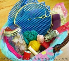 a blue purse filled with lots of crafting supplies on top of a wooden table