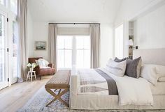 a bedroom with a large bed and white walls