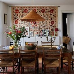 a dining room table with chairs and a basket hanging from the ceiling next to it