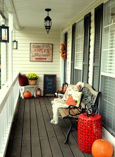 the front porch is decorated with pumpkins and other decorations