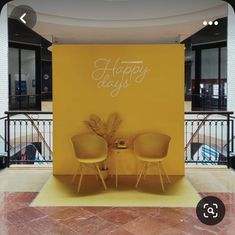 two yellow chairs sitting next to each other on top of a tile floor in front of a sign that says happy days