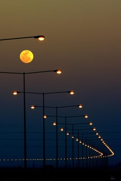 the full moon is seen through some street lights in black and white, as well as many street lamps