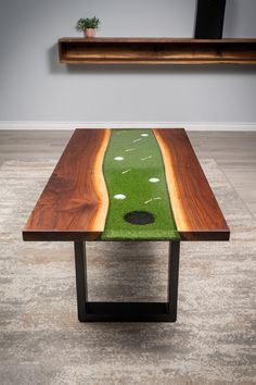 a wooden table with green grass and holes on it