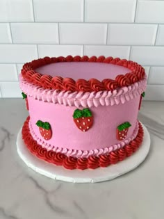 a pink and red cake with strawberries on it