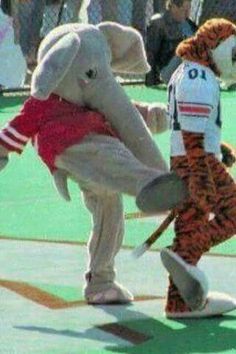 a person in an elephant costume kicking a stuffed animal