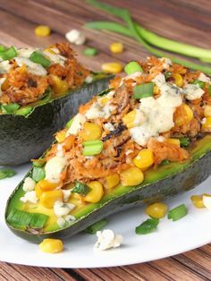 two stuffed zucchini boats filled with meat and veggies on a white plate