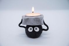 a candle that has been placed in the shape of a ball with eyes on it