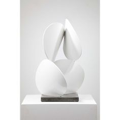 a white sculpture sitting on top of a wooden block