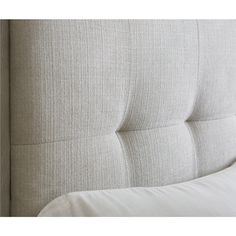 an upholstered headboard with white pillows