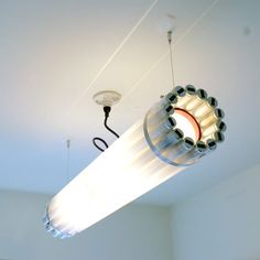 a light fixture is suspended from the ceiling in a room with white walls and flooring