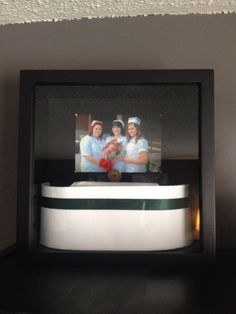 two nurses in scrubs are sitting behind a bowl with flowers on the bottom shelf