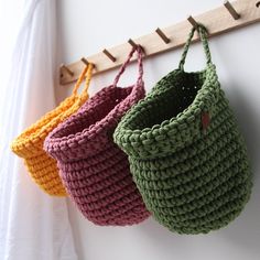 three crocheted baskets hanging from a hook