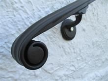 a close up of a black handle on a white wall