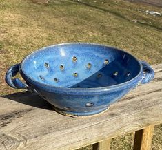 a blue bowl sitting on top of a wooden bench