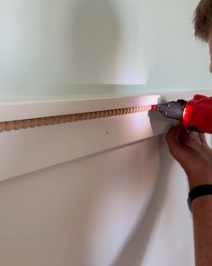 a man using a drill to fix a wall