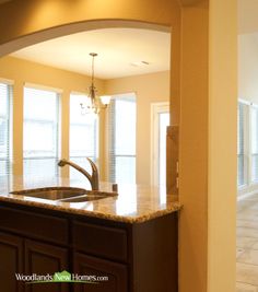 an empty kitchen with marble counter tops and cabinets