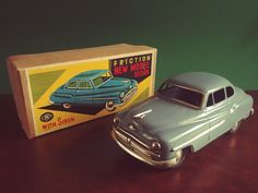 an old model car next to a box on a table