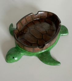 a ceramic turtle shaped bowl sitting on top of a table