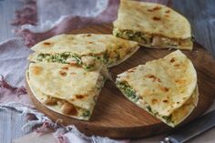 three quesadillas cut in half on a wooden cutting board with a knife